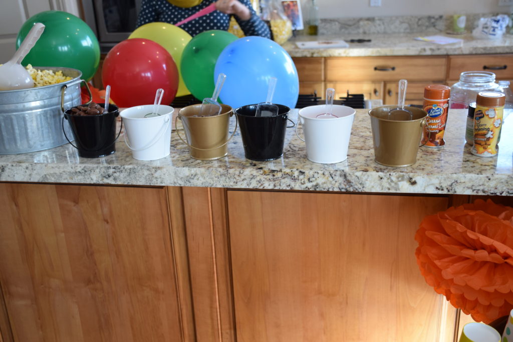 Popcorn bar with candies in buckets and sprinkles