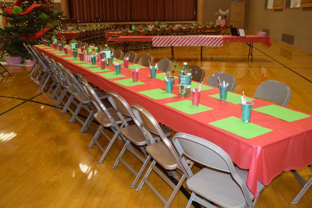 Giant Christmas tree decorated with red and green in the middle of rows of tables