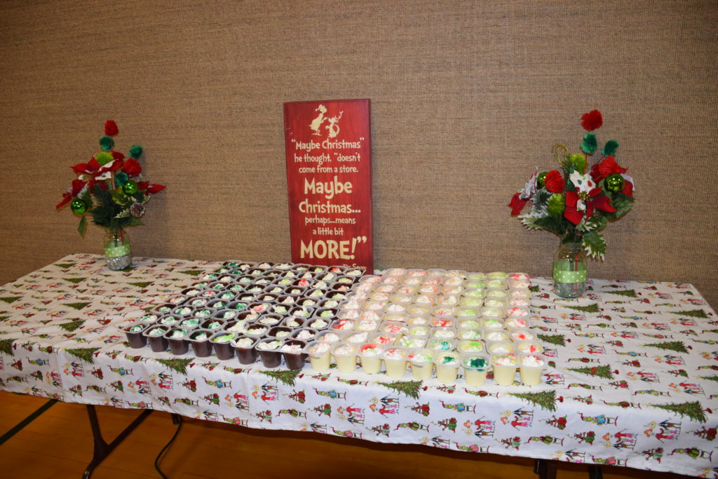 Cups of pudding with Grinch sign behind them