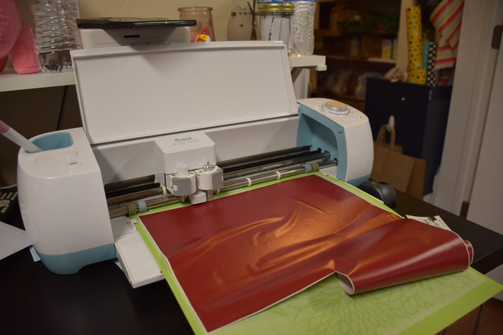 Cricut machine with red vinyl ready to be cut