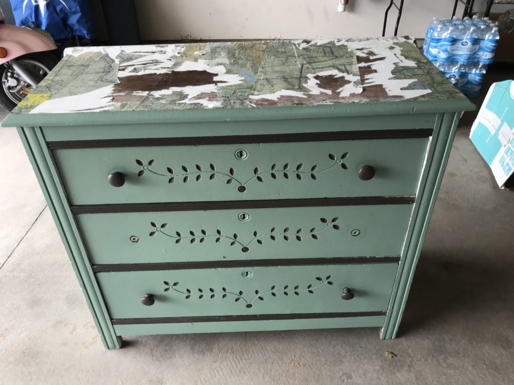 Dresser with maps glued on top and green drawers