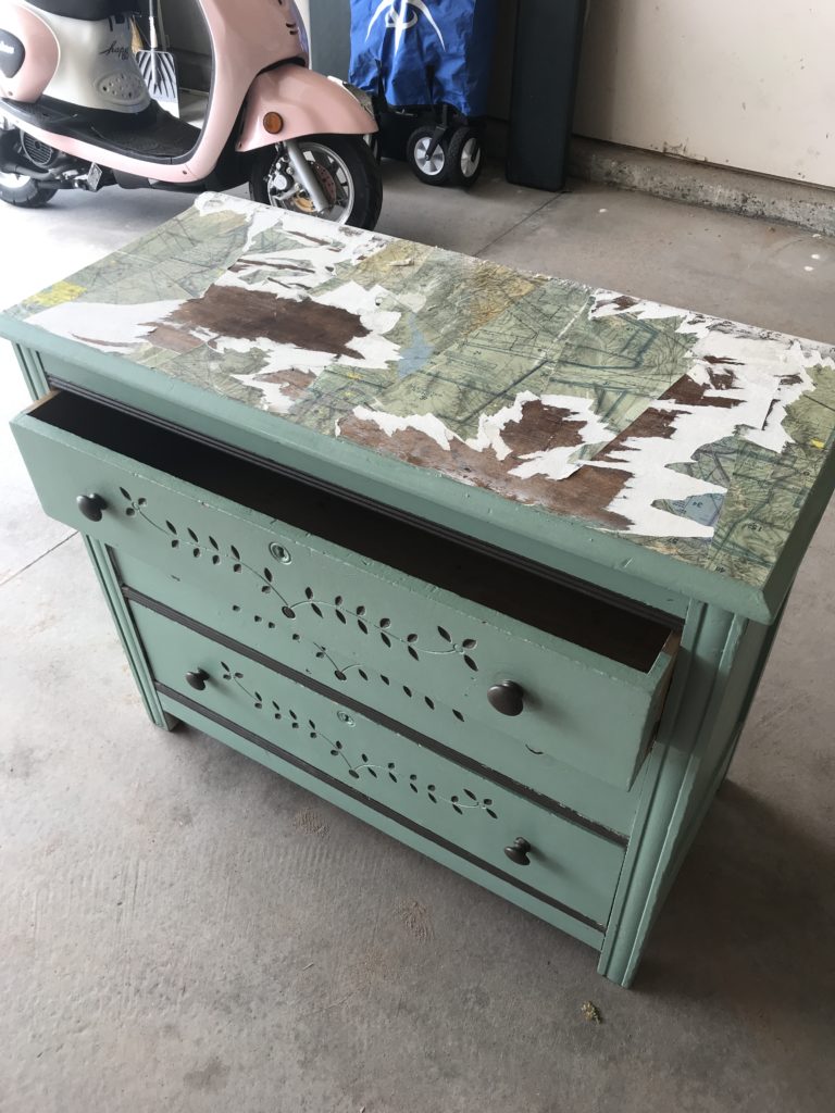 Dresser with maps glued on top and green drawers