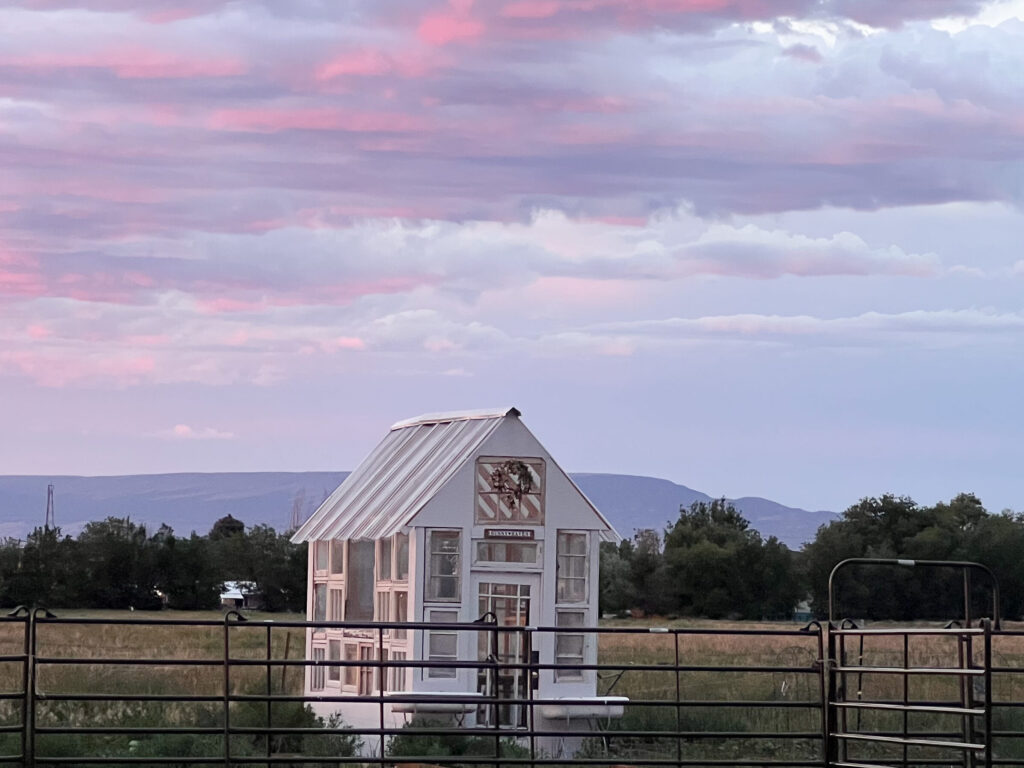 Greenhouse made from old wooden windows in the sunset