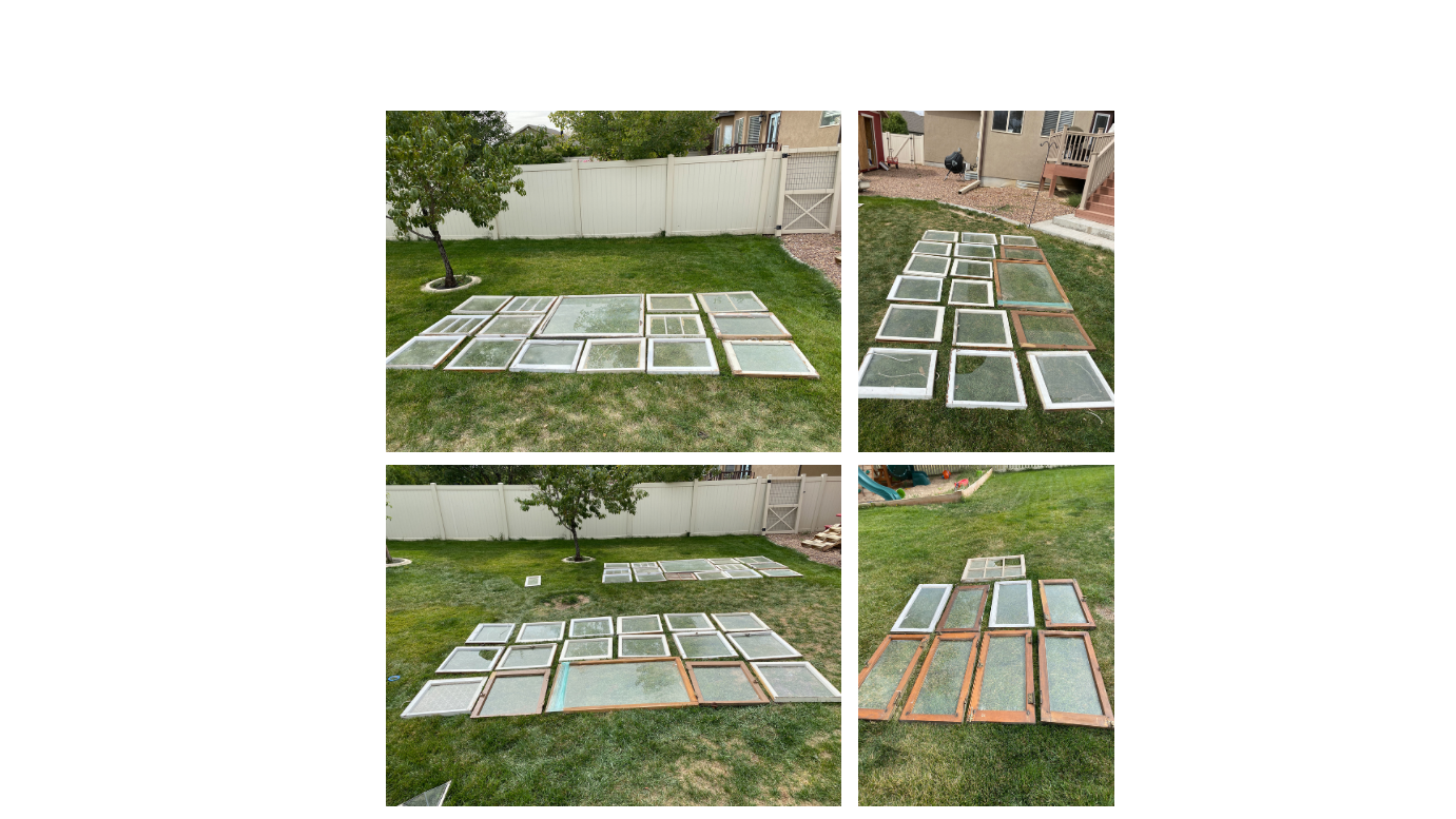 Wooden windows laid out on lawn in pattern to make walls