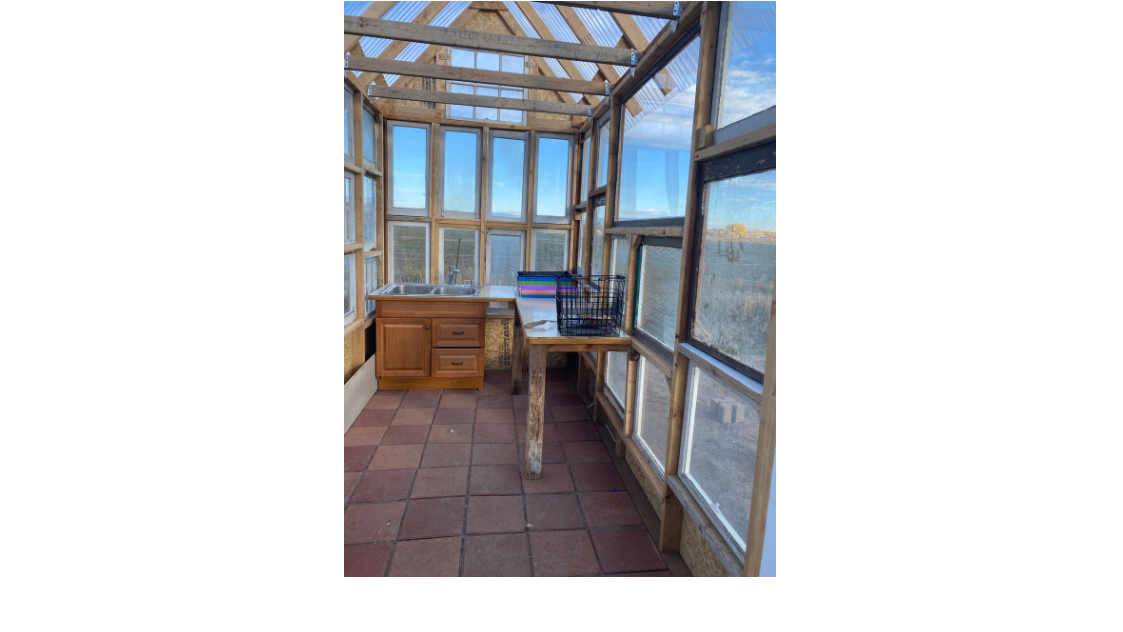 Inside of greenhouse with table and cabinet