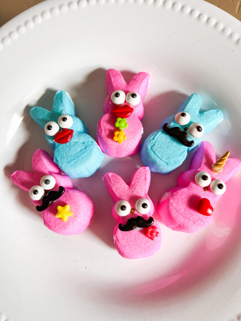 Pink  and blue Peeps bunnies with eyeball candies, mustache, lips and unicorn horn.