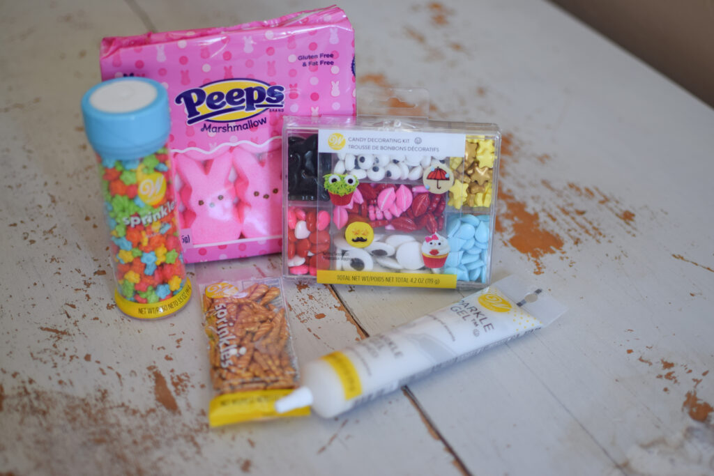 Assorted candy and sprinkles with gel writing icing and a package of peeps.