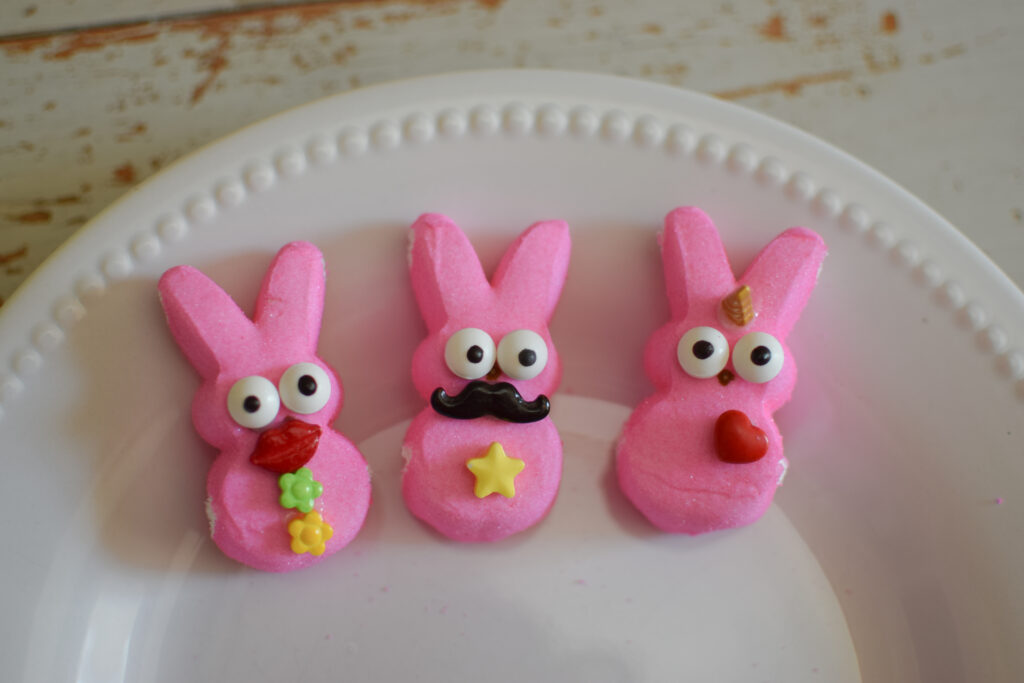 Pink Peeps bunnies with eyeball candies, mustache, lips and unicorn horn.
