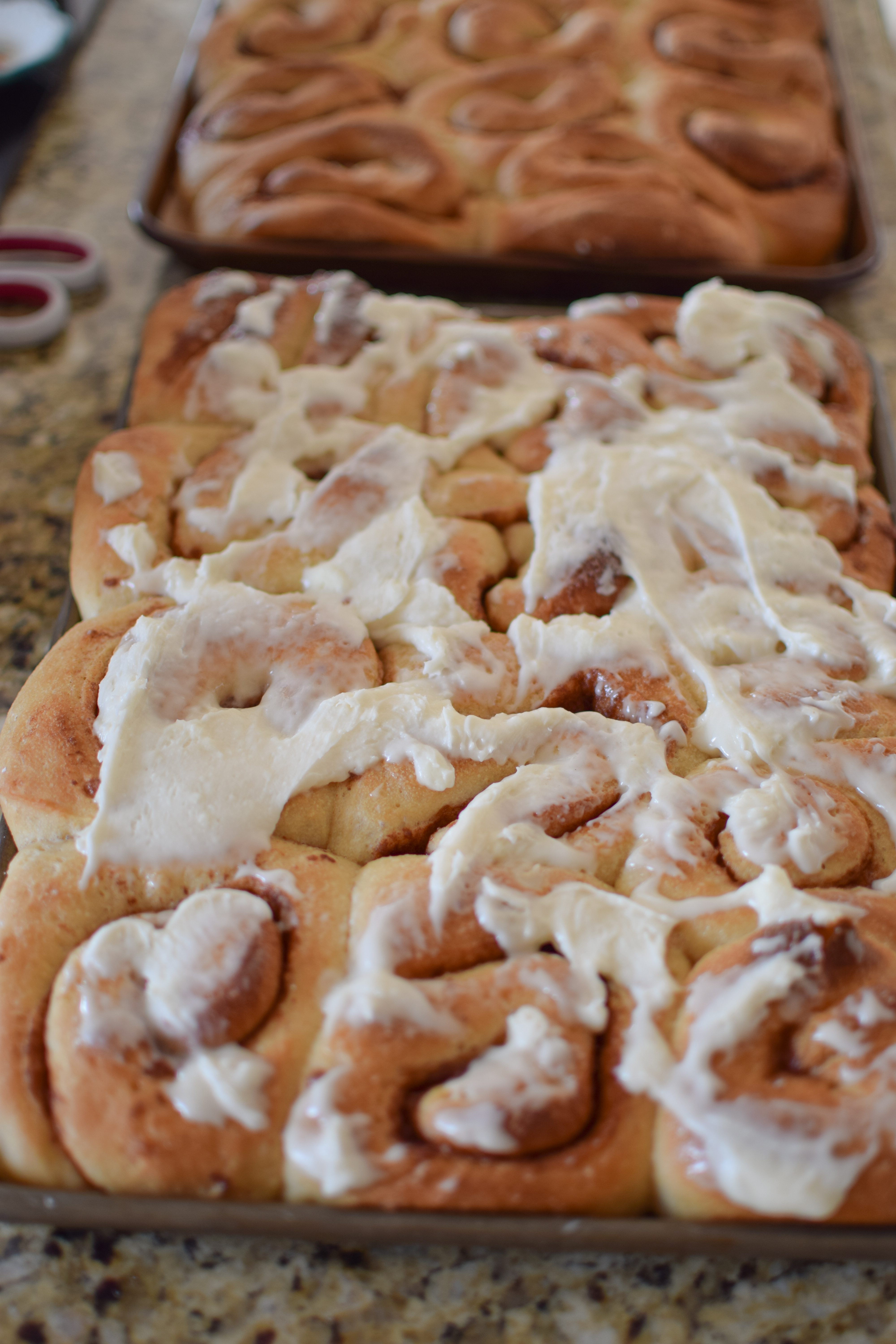 Whole wheat cinnamon rolls being frosted