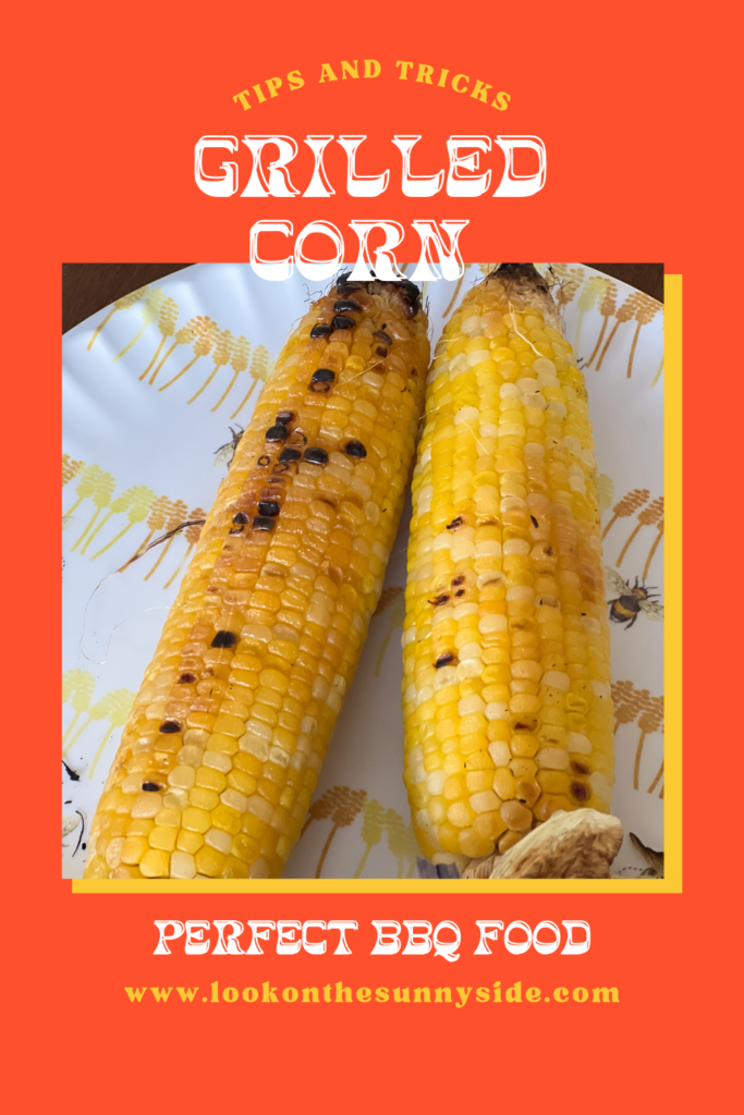 Two pieces of grilled corn on a plate